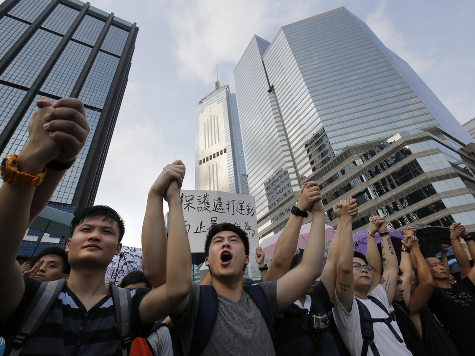 Protesters shout slogans outside a flag-raising ceremony that Hong Kong's embattled leader, Chief Executive Leung Chun-ying, attended in Hong Kong on Wednesday. (Vincent Yu/AP)