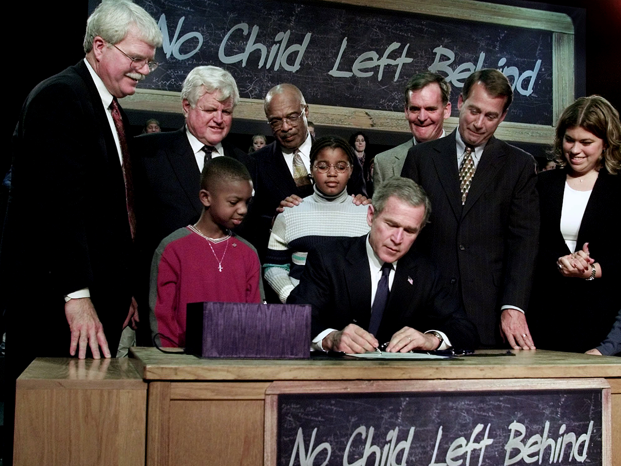 President George W. Bush, seated, signs No Child Left Behind into law at Hamilton High School in Hamilton, Ohio. (ASSOCIATED PRESS)