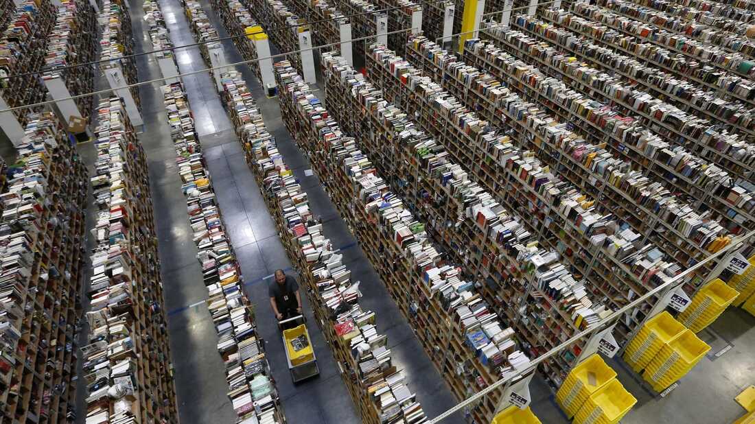 An Amazon.com employee walks down one of the miles of aisles at an Amazon.com Fulfillment Center in Phoenix.