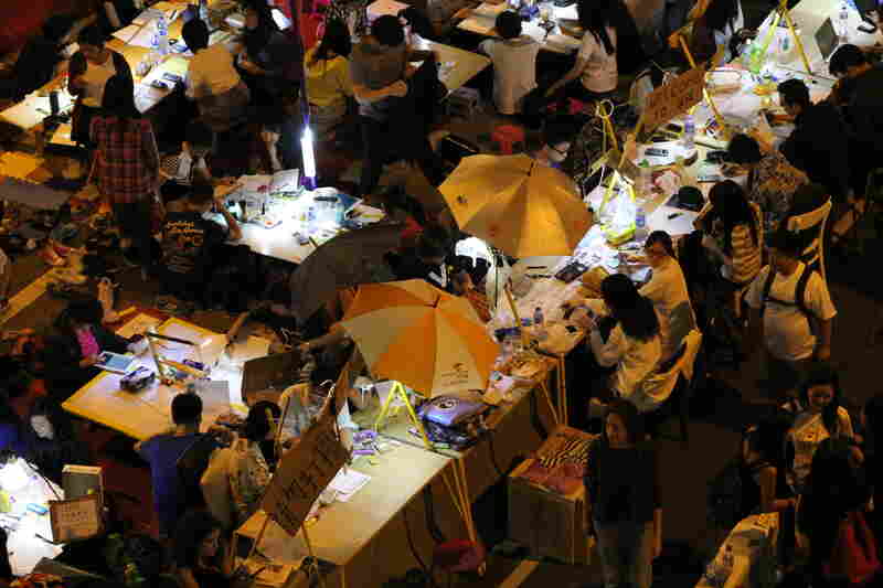 Student demonstrators don't want to fall behind on their studies, so volunteers built them an outdoor study hall. Some of the desks are built into the concrete highway divider.