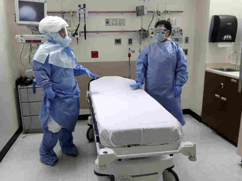 Nurse Belkys Fortune (left) and Teressa Celia, Associate Director of Infection Prevention and Control, pose in protective suits in an isolation room at Bellevue Hospital in N.Y. during a demonstration of procedures for possible Ebola patients, on Oct. 8, 2014.
