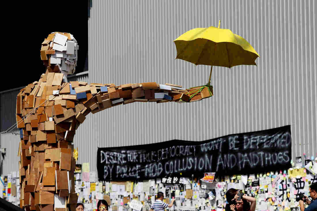 A scrap-wood sculpture of a man holding an umbrella is the contemporary equivalent of the "Goddess of Democracy." The umbrella became a symbol of the democracy demonstrations after protesters used them to block police pepper spray and tear gas attacks late last month.