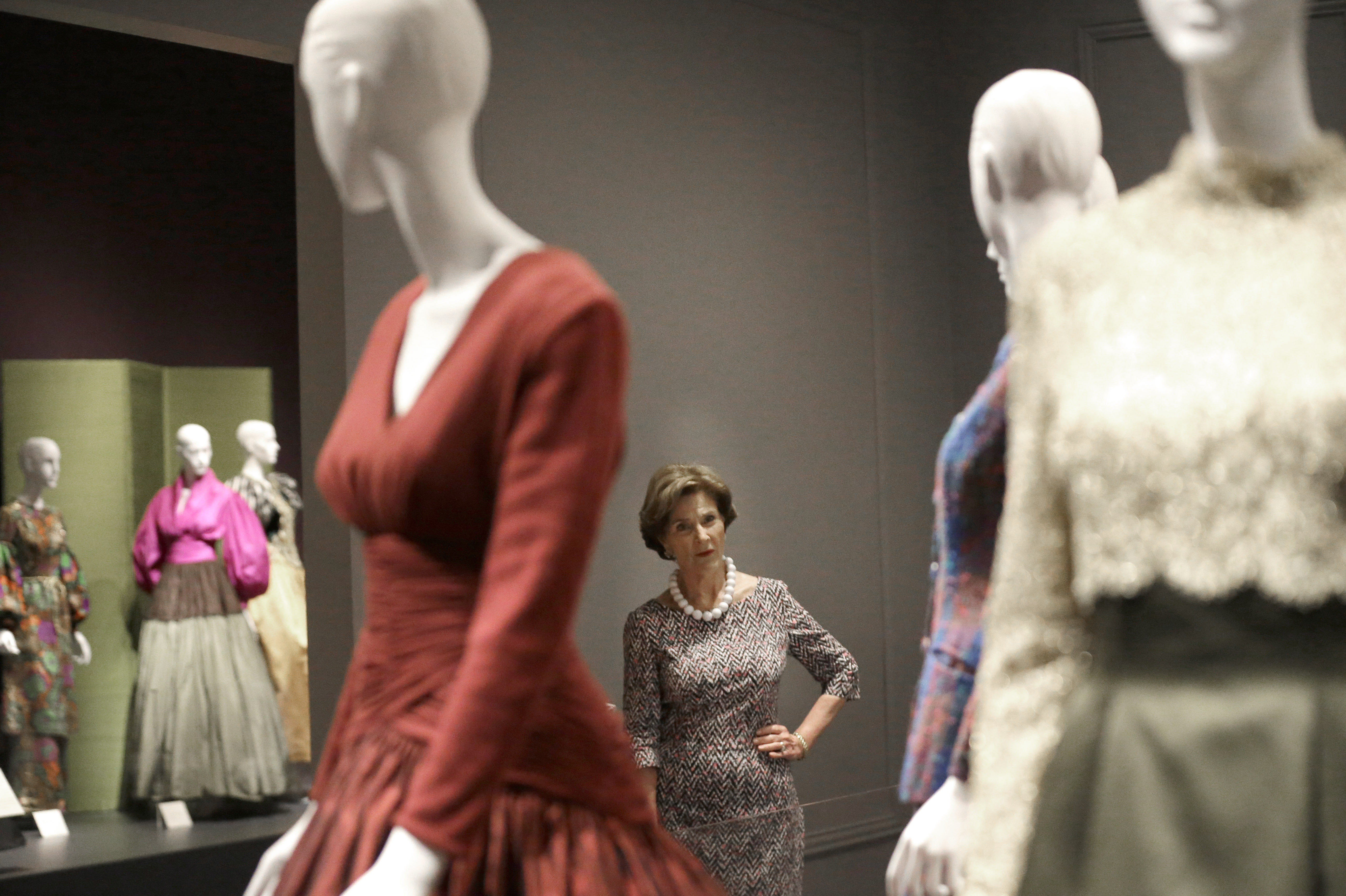 Former first lady Laura Bush with Oscar de la Renta outfits on display in Dallas in July for a retrospective on the designer's career at the George W. Bush Library and Museum.