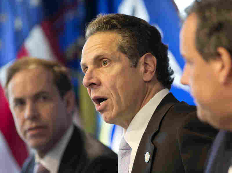 New York Governor Andrew Cuomo (center) speaks at a news conference on Oct. 24, 2014 in New York, announcing a mandatory quarantine for people returning to the United States through airports in New York and New Jersey who are deemed "high risk."