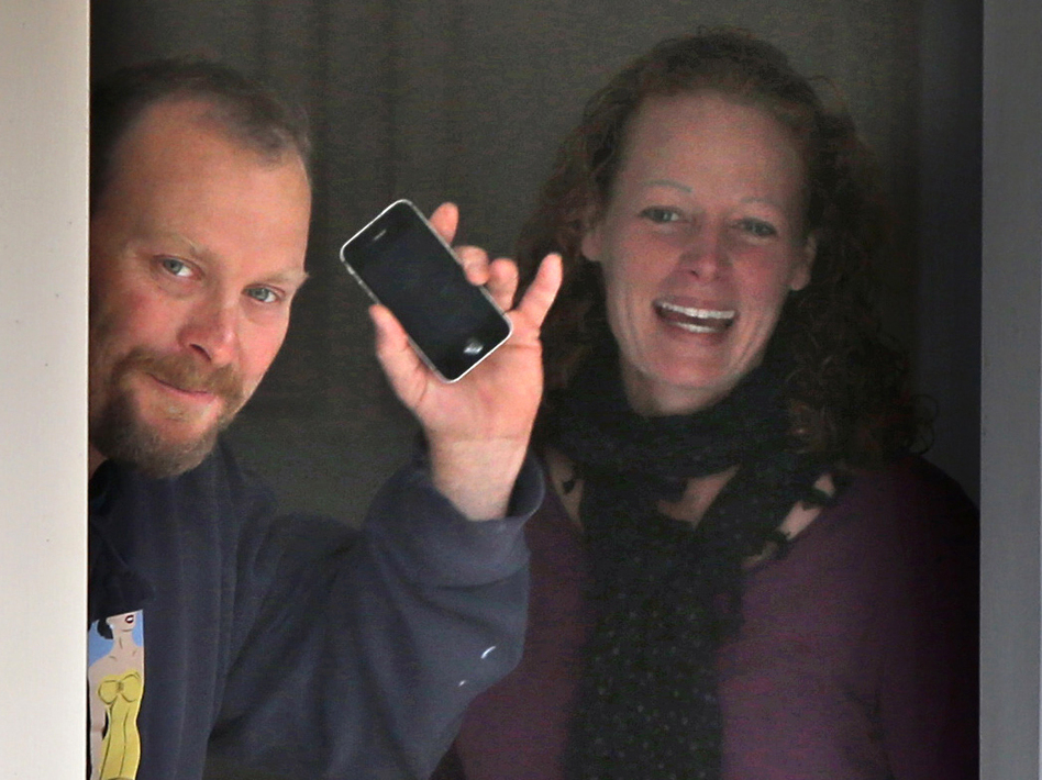 Nurse Kaci Hickox and her boyfriend, Ted Wilbur, take delivery of a pizza at their home in Fort Kent, Maine, on Thursday. A judge has ruled that the state cannot compel Hickox to remain in isolation if she's not showing signs of Ebola infection. (Robert F. Bukaty/AP)