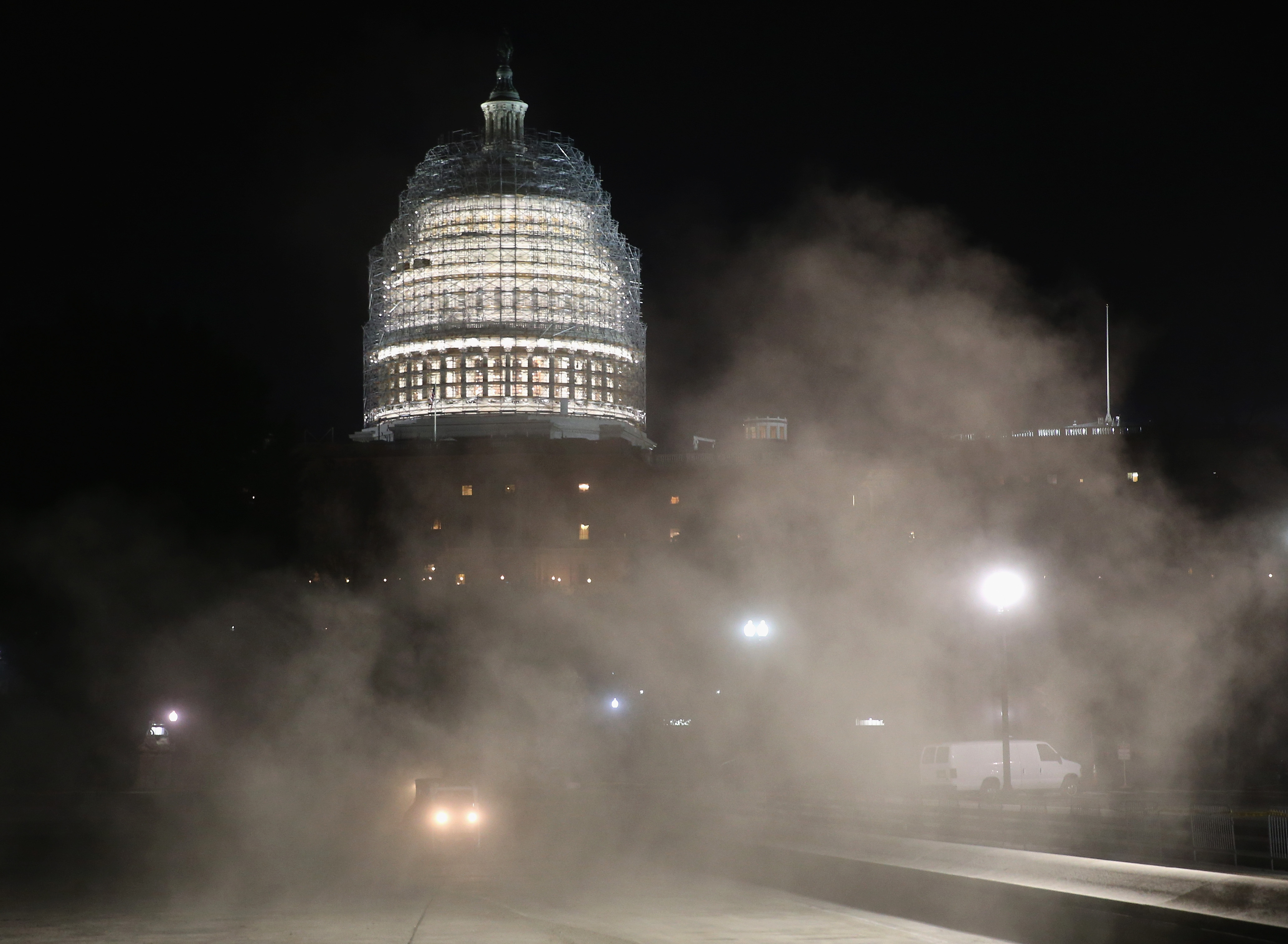 Sweepers stir up dust as they clean the reflecting pool in front of the U.S. Capitol on Tuesday.