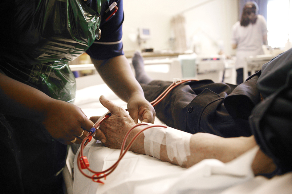 A nurse adjusts the position of a patient's arm during dialysis treatment. The treatment requires trained staff that weren't readily available in the aftermath of Hurricane Sandy. (Michael Donne/Science Source)