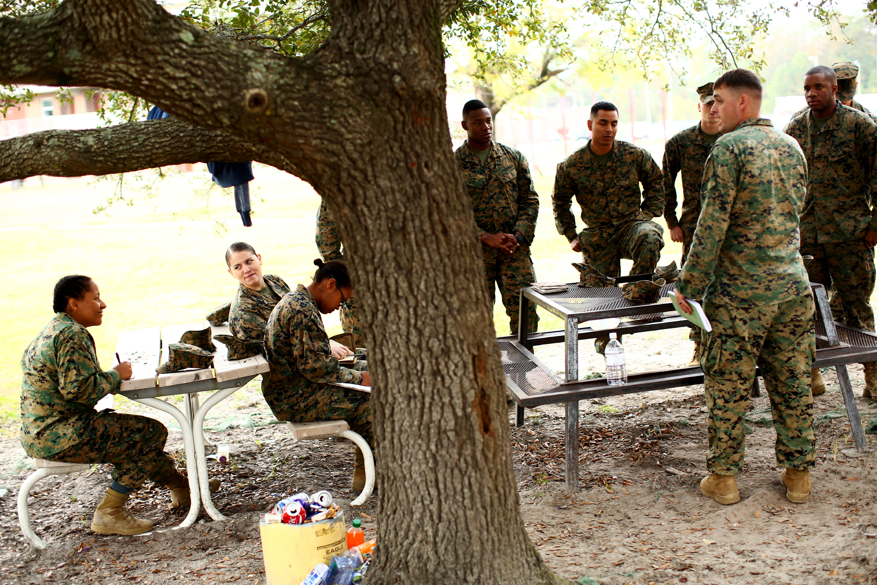 Male and female Marines gather for class in a courtyard outside the barracks.