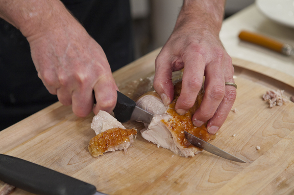 Chris Kimball slices up some cooked heritage turkey.