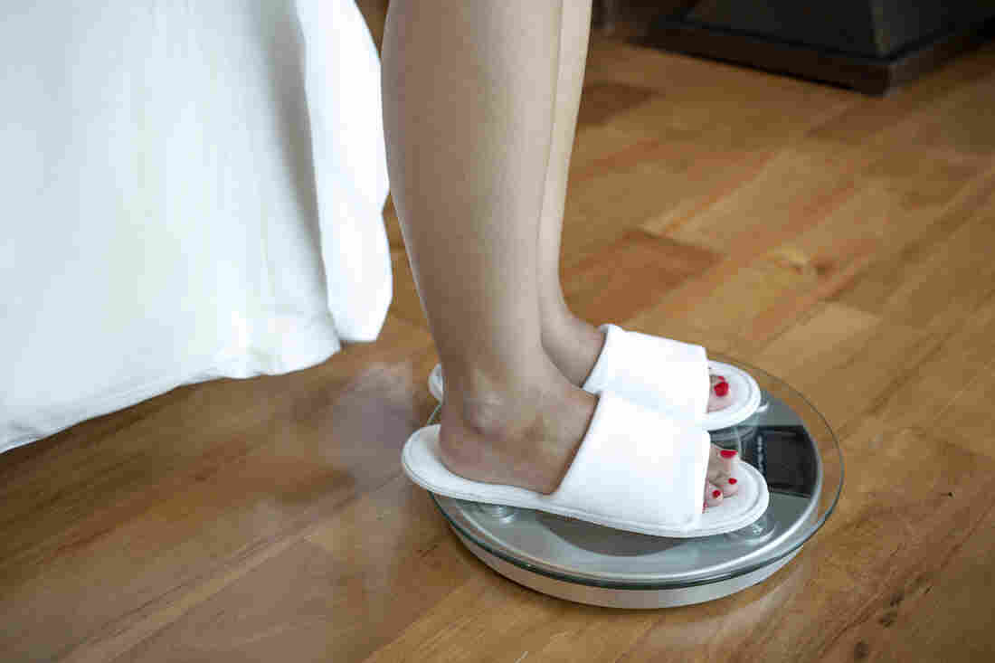 Asian woman on a scale.