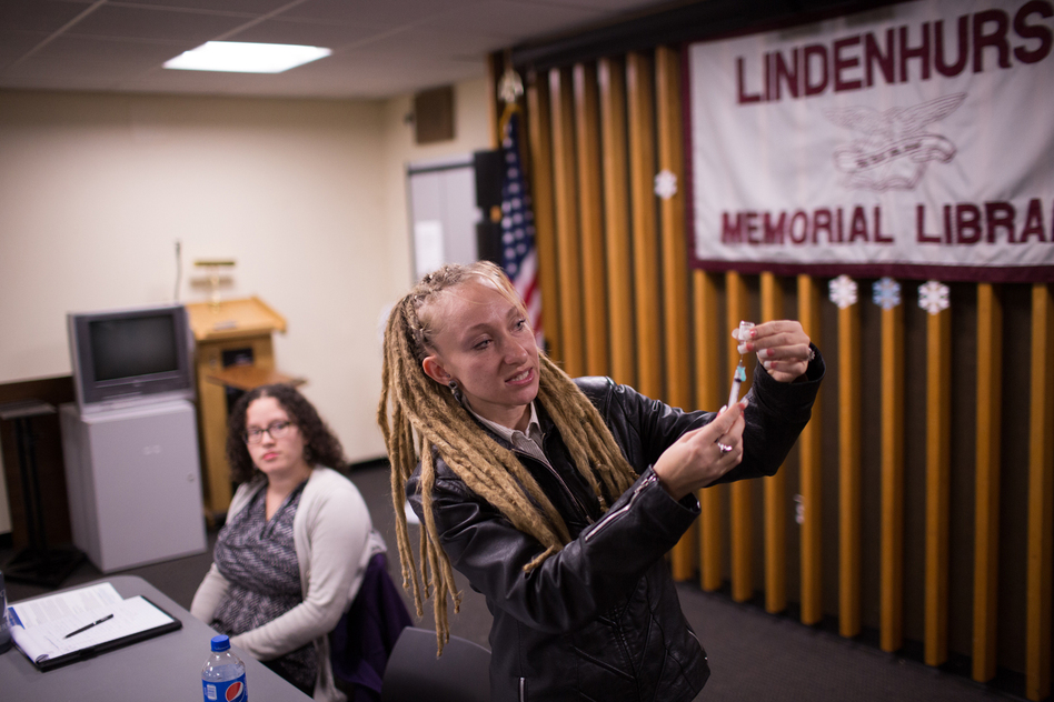 Tina Wolf demonstrates the use of naloxone to community members in Lindenhurst, N.Y., during an overdose prevention training. Georgia Dolan-Reilly (left) of the Suffolk County Prevention Resource Center helped with the training. (Kevin Hagen for NPR)