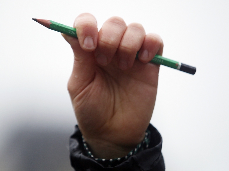 A man holds a pencil in the air during a minute of silence in Paris on Thursday for the cartoonists and other victims of gunmen on the offices of French satirical newspaper <em>Charlie Hebdo</em>. (Matthieu Alexandre /AFP/Getty Images)