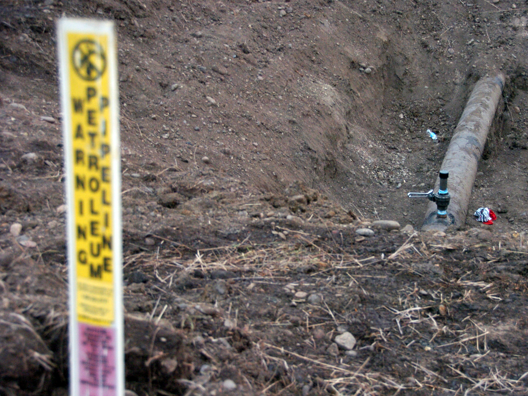 A warning sign shows the location of a 12-inch oil pipeline owned by Bridger Pipeline Co. that spilled up to 50,000 gallons of crude along the Yellowstone River near Glendive, Mont.