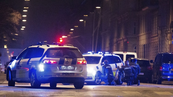 Police officers take cover behind their patrol cars on the streets of central Copenhagen on Sunday, after a shooting near Copenhagen's main synagogue left one person dead. It was not confirmed if the incident was related to Saturday's deadly shooting at a cultural centre in Copenhagen where a debate on Islam and free speech was being held.