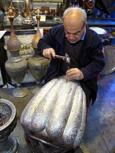 Asghar Pourheydar-Shirazi uses a hammer and a nail to engrave intricate patterns on a vase at his shop in Isfahan. He was optimistic following the country's 1979 revolution, but says the economy has fared poorly for decades. At 64, he works 10 to 12 hour days. Asghar Pourheydar-Shirazi uses a hammer and a nail to engrave intricate patterns on a vase at his shop in Isfahan. He was optimistic following the country's 1979 revolution, but says the economy has fared poorly for decades. At 64, he works 10 to 12 hour days.