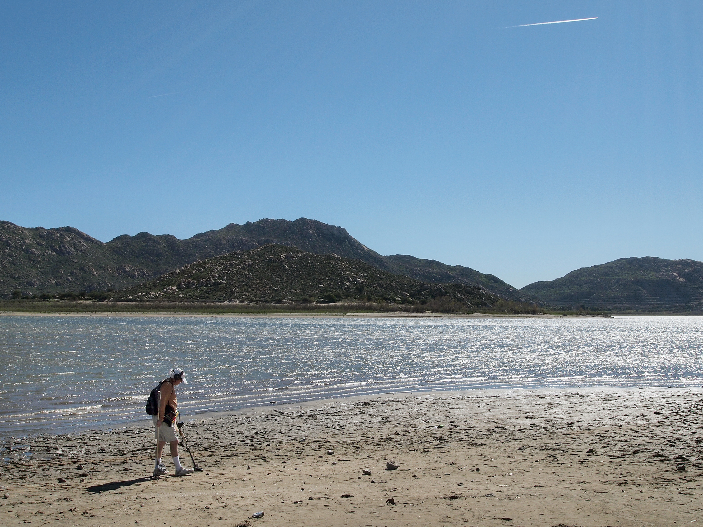 Marty Gabriel, a retired truck driver, passes his metal detector over the exposed sand at California's Lake Perris. Gabriel has been visiting the lake for 25 years. "We definitely need rain," he says.
