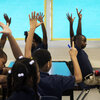 Students at KIPP Central City Primary School raise their hands during a social studies class on August 14, 2014 in New Orleans. The school's student body is nearly 100 percent black in a system that is 85 percent black.