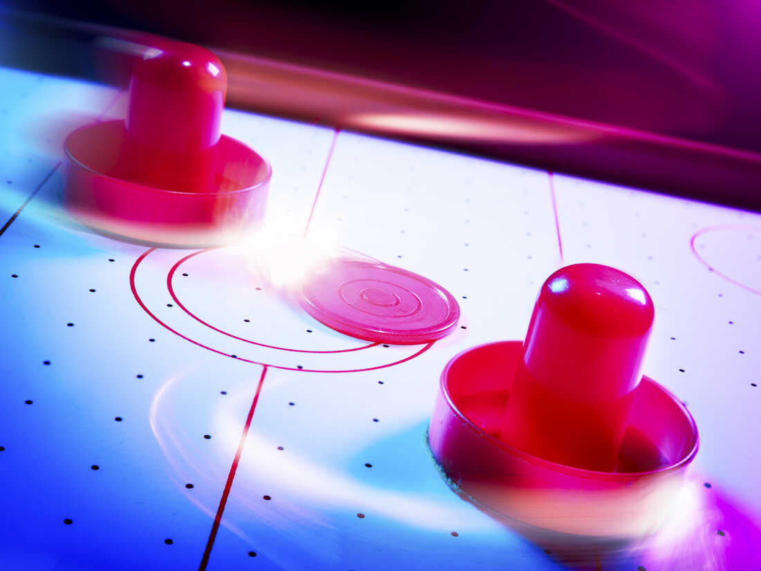 Air hockey table with dramatic lighting and motion trails