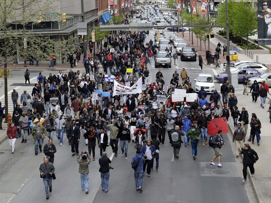 Earlier this week, protesters marched for Freddie Gray through downtown Baltimore. Gray died from spinal injuries about a week after he was arrested and transported in a police van. A larger protest is planned for Saturday afternoon. (Patrick Semansky/AP)