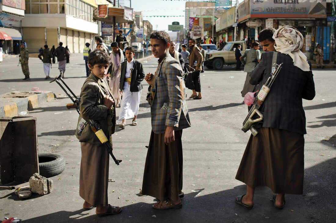 A young boy carries a rifle in Yemen's capital Sanaa. When photographer Alex Potter arrived in Yemen in 2012, men had guns but rarely displayed them publicly. Now, as the country has collapsed into civil war, men and boys are often armed.