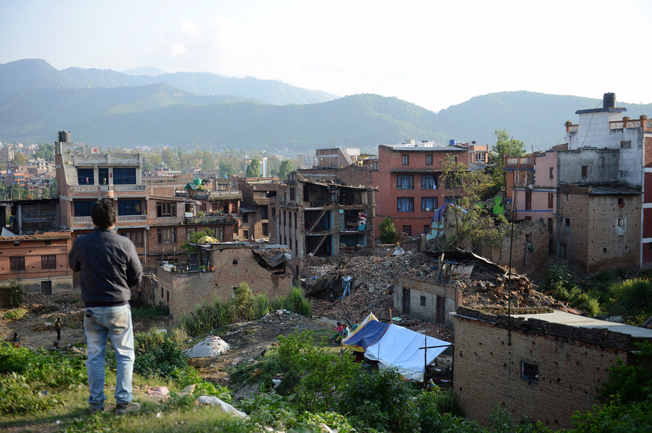 A man stands near collapsed houses in Bhaktapur, on the outskirts of Kathmandu, on April 27, two days after a magnitude-7.8 earthquake hit Nepal. Aftershocks tend to get less frequent with time, scientists say, but not necessarily gentler. (Prakash Mathema/AFP/Getty Images)