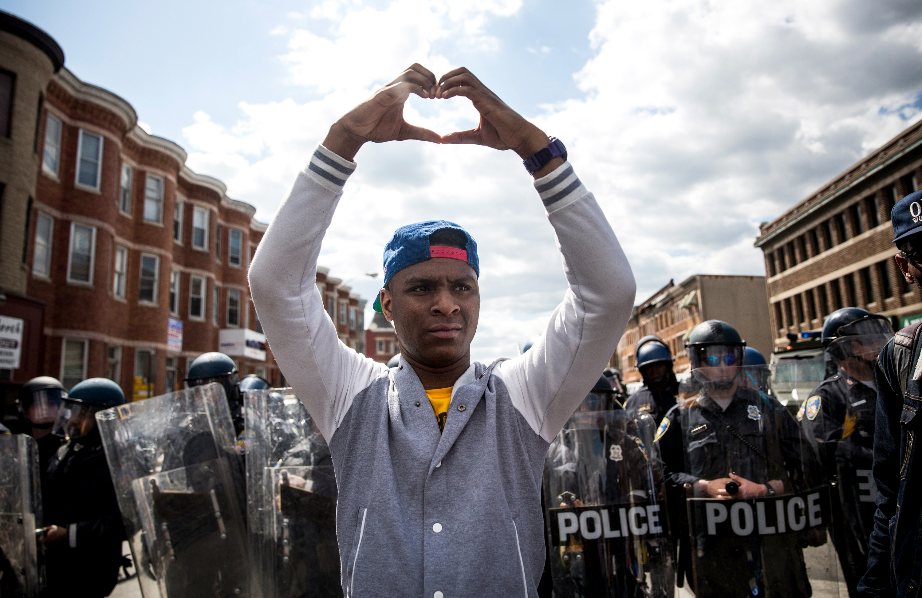 A man makes a heart shape with his hands during a peaceful protest near the CVS pharmacy that was set on fire on Monday in Baltimore. (Getty Images)