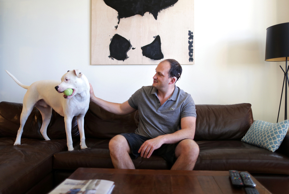 Sam Swiller and his dog, Sully, in their home in Washington, D.C. (Meredith Rizzo/NPR)