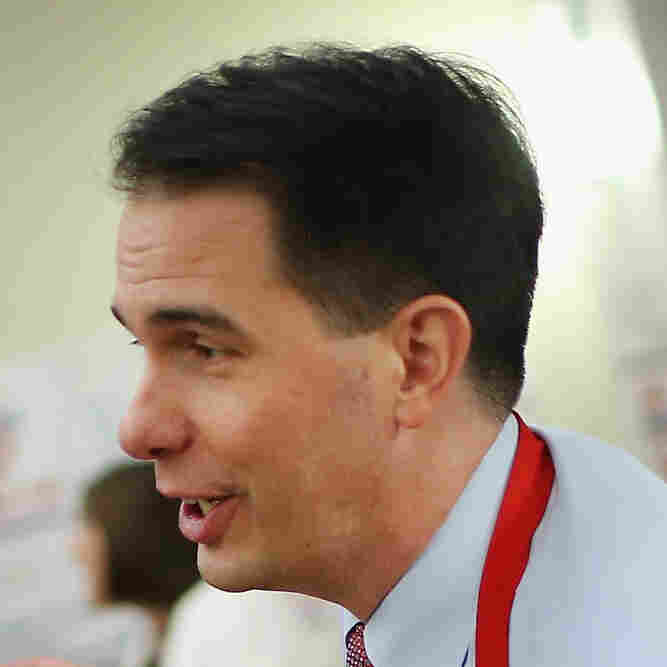 Wisconsin Gov. Scott Walker offers cheese and ice cream to guests in his hospitality room at the Iowa Lincoln Day Dinner in Des Moines on Saturday.