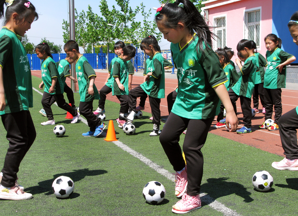 First-graders take soccer class at the Nandulehe Elementary School in suburban Beijing. The school is one of 20,000 that's launching a national soccer curriculum in the next five years. It's part of a government plan to raise China's soccer skills and eventually, China's leaders hope, host and win a World Cup. (Anthony Kuhn/NPR)