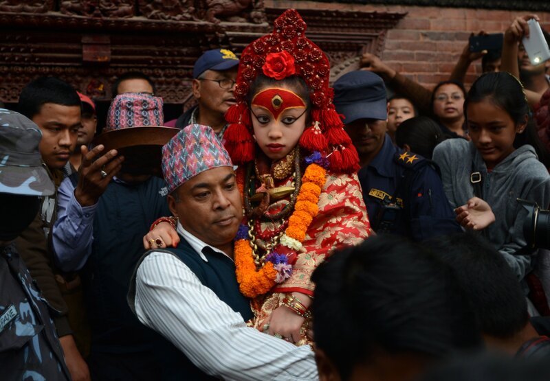 Nepal's Living Goddess, the Kumari Devi, 9, observes a chariot festival in Kathmandu on March 29. The goddess is worshipped by both Hindus and Buddhists. She's selected as a young child and lives an isolated and secretive existence and is rarely seen in public. Her historic home survived last month's earthquake with only minor cracks. She's being held by her caretaker Gautam Shakya.