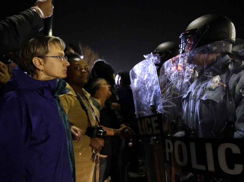 Police and protesters square off outside the Ferguson Police Department, in March.Earlier in the day, the resignation of Ferguson police chief Thomas Jackson was announced in the wake of a scathing Justice Department report prompted by the fatal shooting of an unarmed black 18-year-old by a white police officer. (Jeff Roberson/AP)