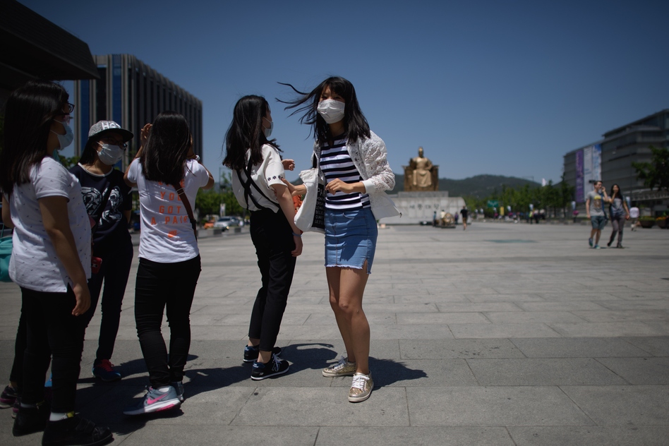 A student wearing a face mask stands in a public square in Seoul on June 3. More than 200 primary schools shut down as South Korea has struggled to contain an outbreak of the MERS virus. (ED JONES/AFP/Getty Images)