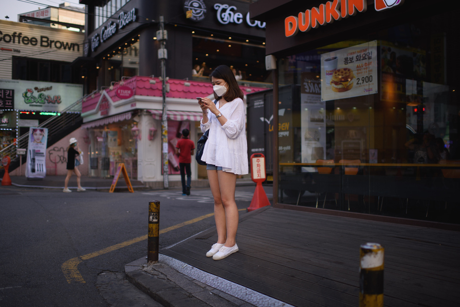 A woman on a street in Seoul checks her cellphone. The government is ramping up efforts to control an outbreak of the Middle East respiratory syndrome by monitoring the smartphones of those under quarantine. (Ed Jones/AFP/Getty Images)