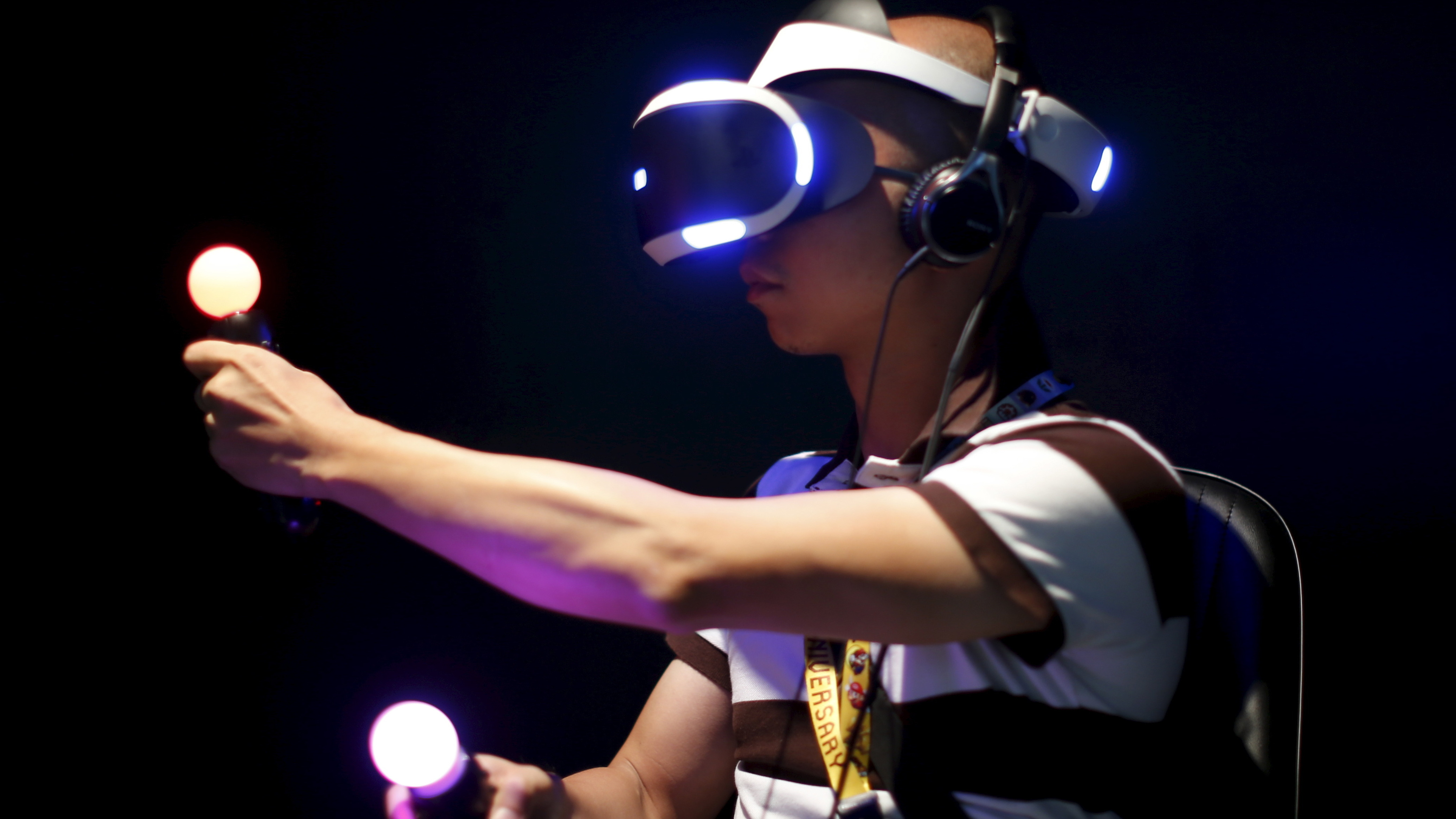 An attendee at the Electronic Entertainment Expo in Los Angeles plays Sony's Project Morpheus London Heist video game with a virtual reality headset and Move controllers. (Reuters/Landov)