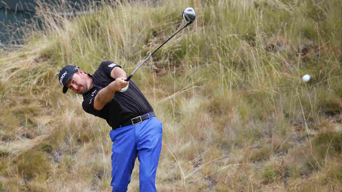 Graeme McDowell, of Northern Ireland, watches his tee shot on the sixth hole during the first round of the U.S. Open golf tournament at Chambers Bay. The brown grass may seem unusual to some American golf fans.