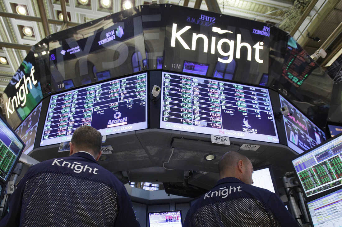 A pair of Knight Capital traders work at their post on the floor of the New York Stock Exchange before the close of trading Aug. 3, 2012. Knight Capital's stock soared after the battered trading firm received a financial lifeline and clients said they expect to resume routing trades through the system.