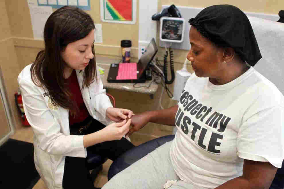 Dr. Annelys Hernandez (left) checks out Cynthia Louis (right) in Florida International University's Mobile Health Center in Miami on March 3, 2015.