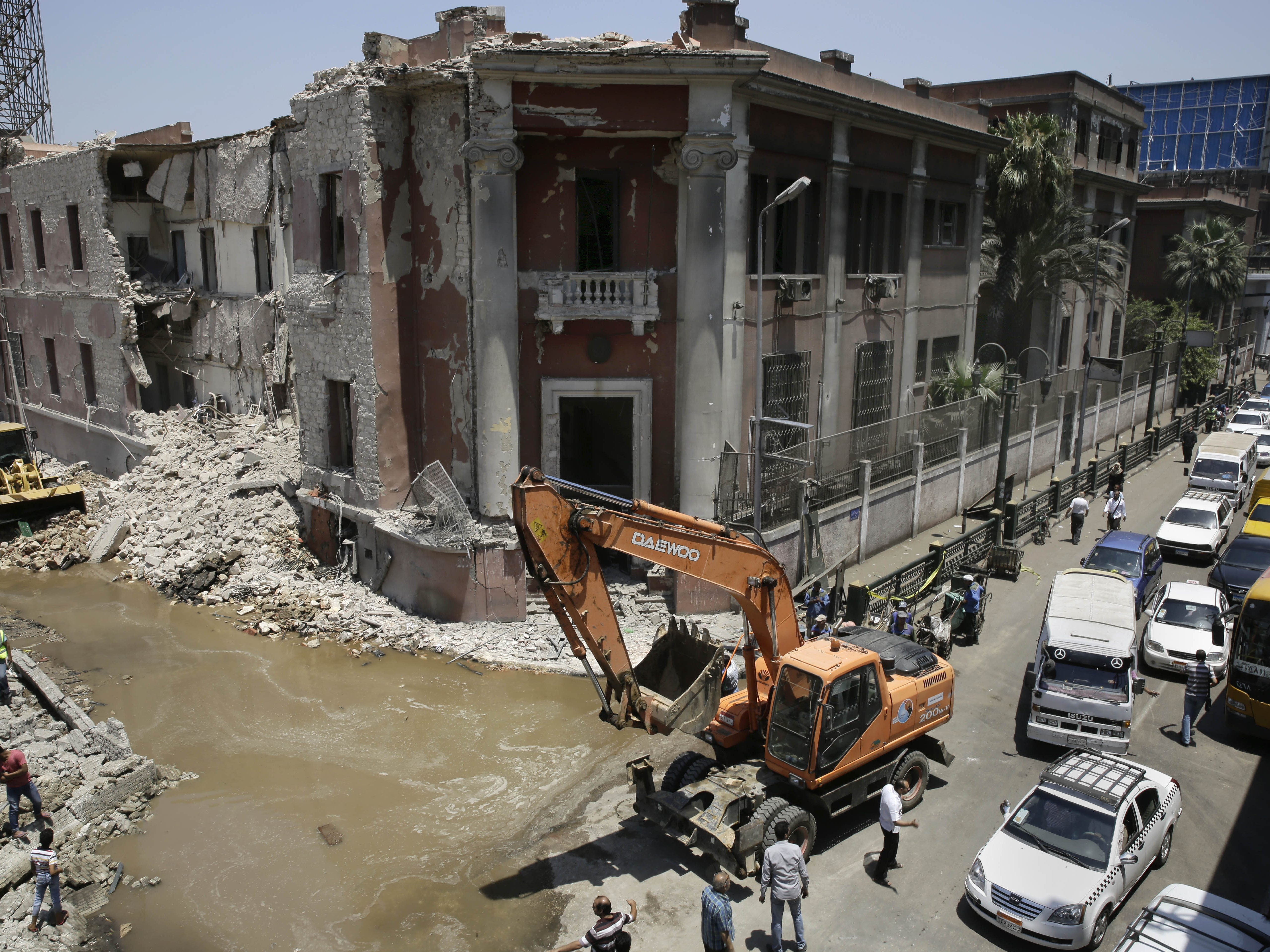 Workers clear rubble at the site of a car bomb explosion near the Italian Consulate in downtown, Cairo, Egypt, on Saturday.