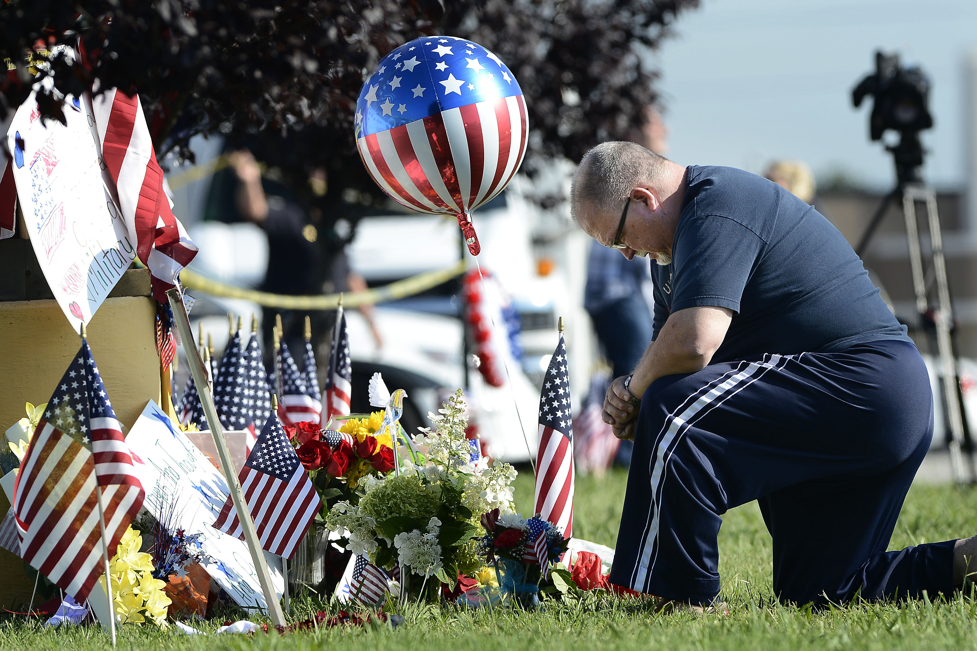 Bill Lettmkuhl kneels by a makeshift memorial near the Armed Forces Career Center on Friday in Chattanooga, Tenn. Mohammod Youssuf Abdulazeez, of Hixson, Tenn., attacked two military facilities on Thursday, in a shooting rampage that killed four Marines.