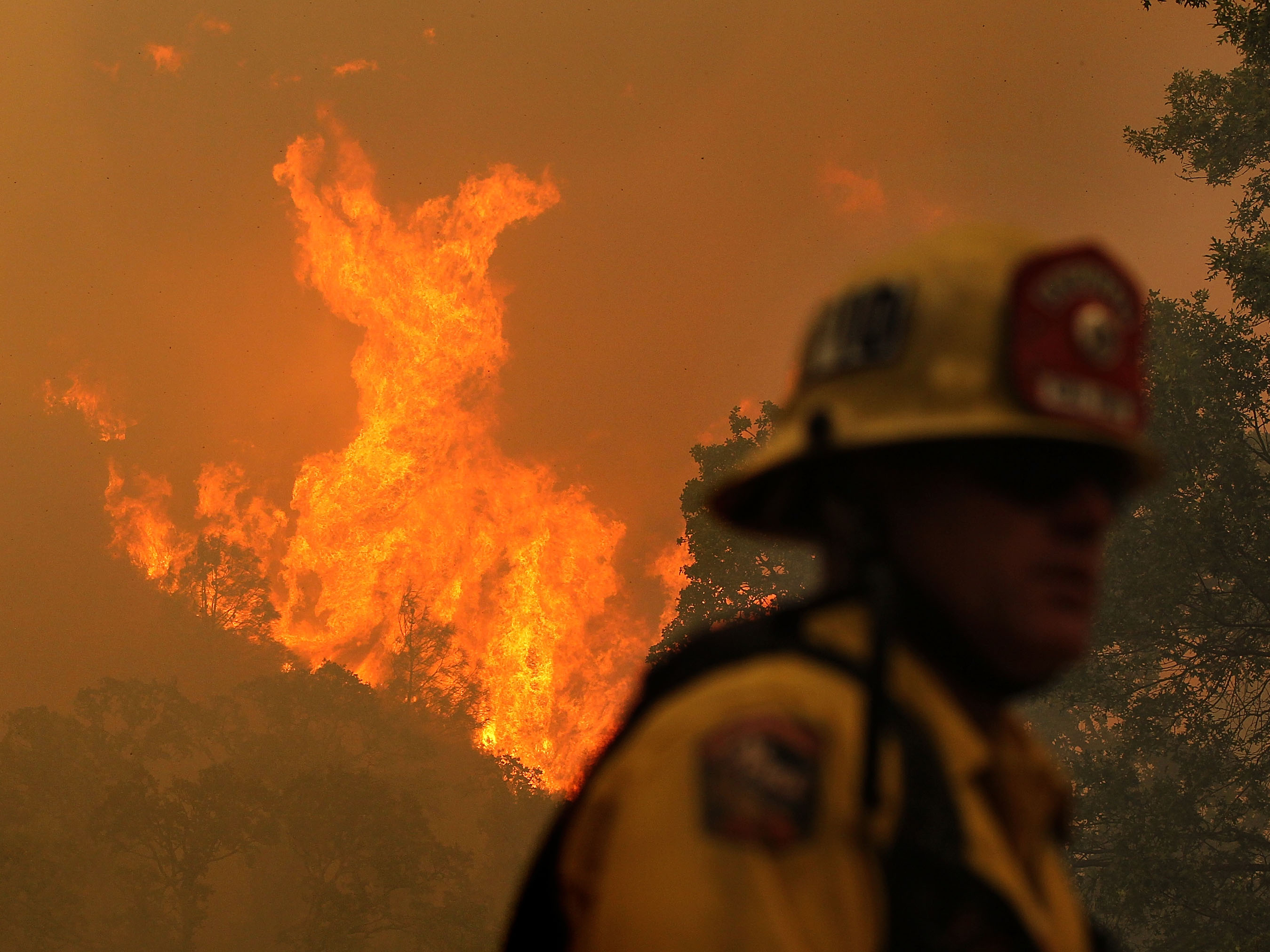 A firefighter monitors flames from the Rocky Fire as it approaches a home late last month. The wildfire has consumed thousands of acres in just over a week. (Getty Images)