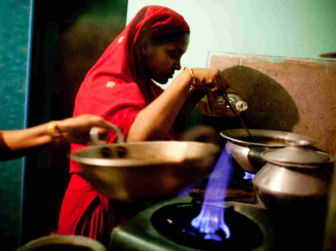 Minu cooks on the two shared burners outside her room in the city.