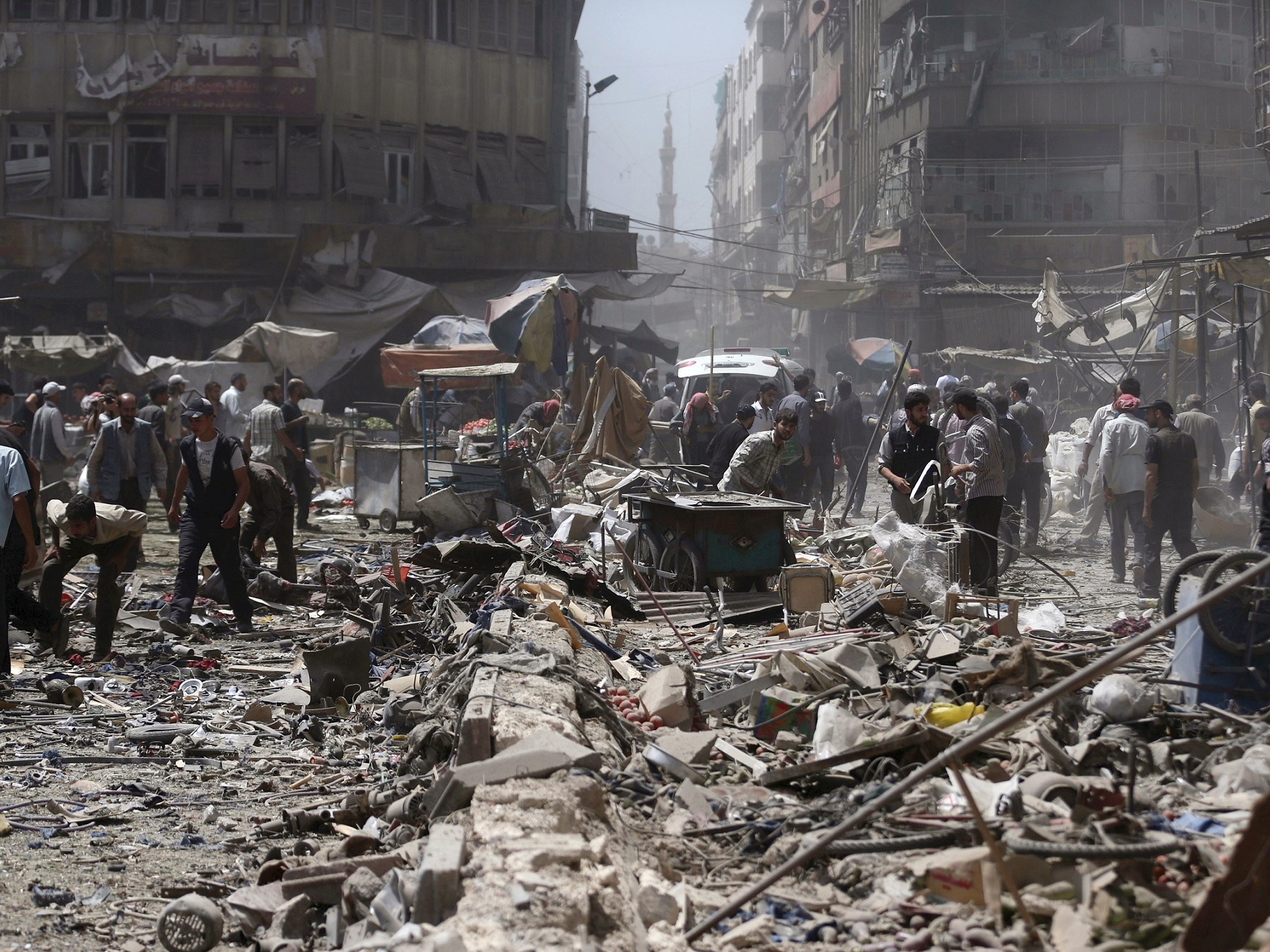 People inspect a site hit by what activists said were air strikes by forces loyal to Syria's President Bashar al-Assad on a marketplace in the Douma neighborhood of Damascus, on Sunday.