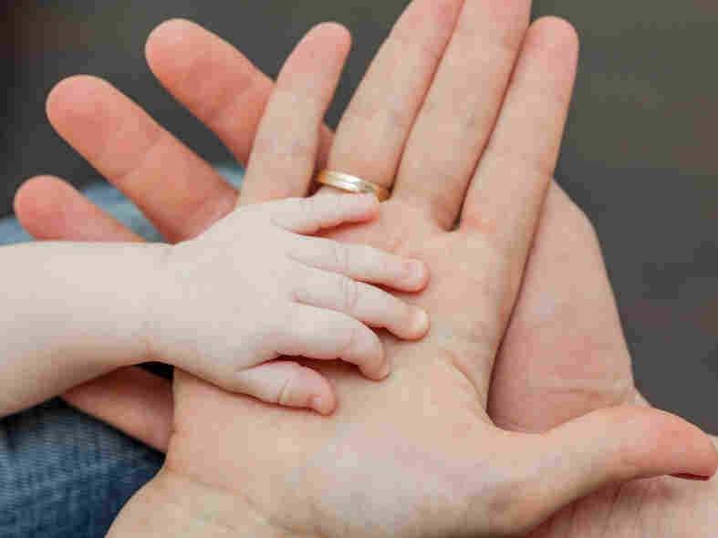 Father and mother holding child's hand.