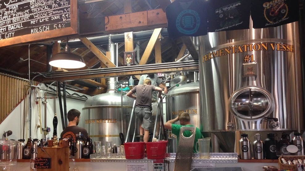 Brewers from Draught Works and the Denver Beer Co. collaborate on making a huckleberry sour beer last weekend at the Draught Works brewery in Missoula, Mont. The beer was kettle soured before being added to the fermentation tank seen here.