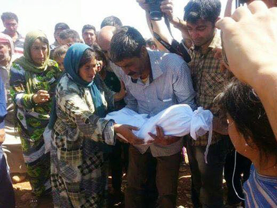 Relatives of 3-year-old Syrian Kurdish boy Aylan Kurdi carry his body during a funeral procession for Aylan, his mother, Rehan, and his older brother, Galip, in Kobani, Syria, on Friday. (Sipan Ibrahim/AP)