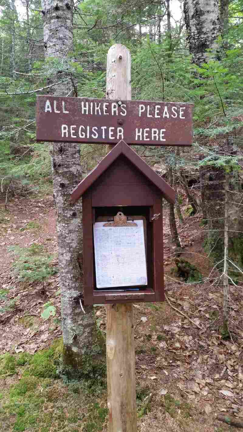 Trail sign instructing hikers to register.