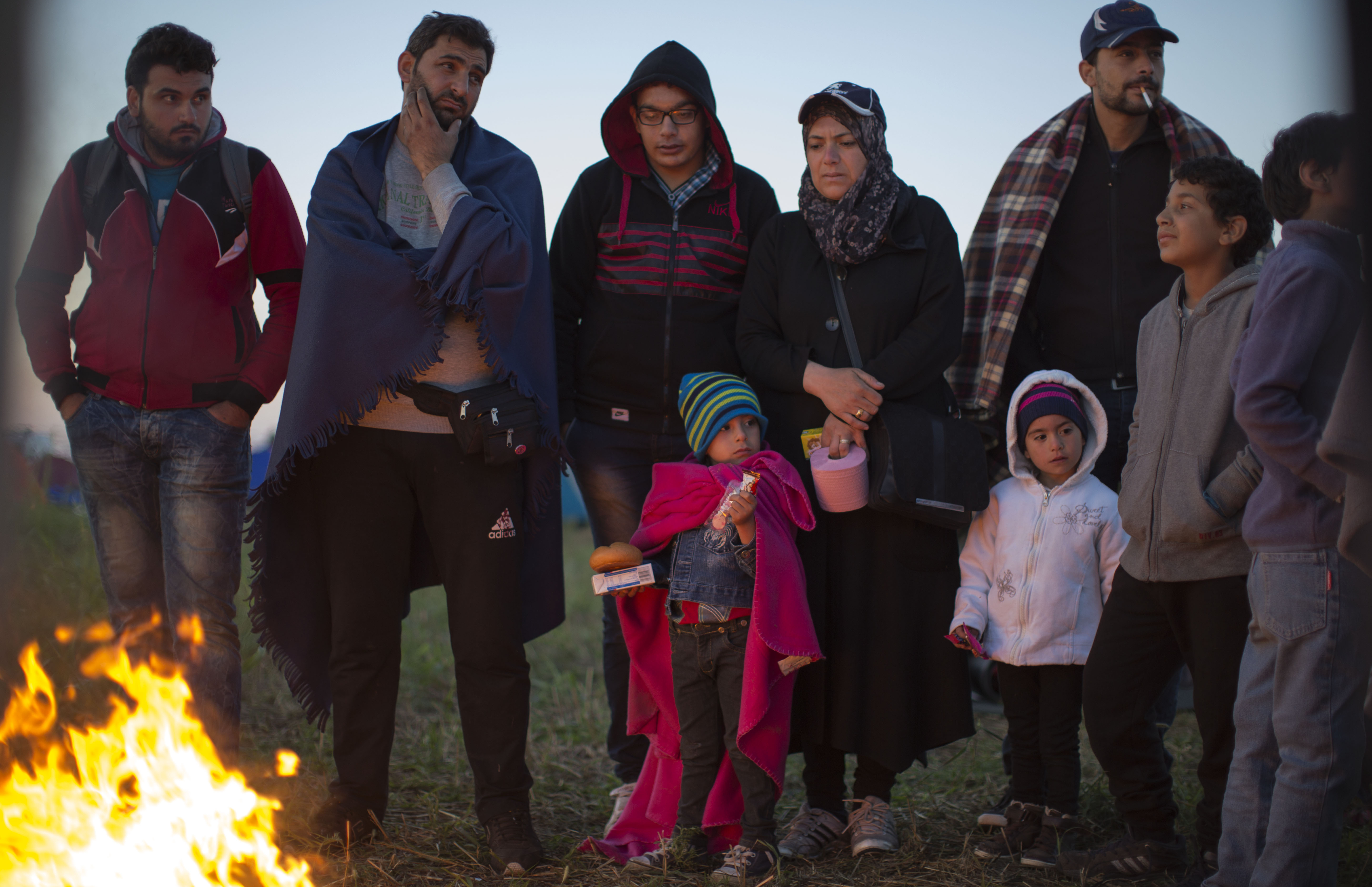 Migrants who crossed the border from Serbia into Hungary Monday night use a fire to keep warm at dawn at a collection point Tuesday. So far in 2015, more than 367,000 refugees and migrants have crossed the Mediterranean to seek safety and better prospects in Europe, the U.N. says.