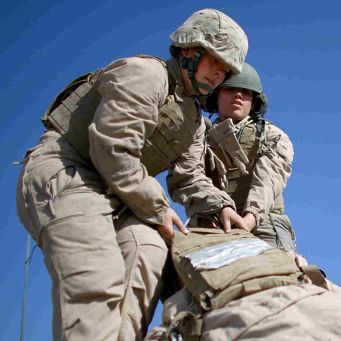 Marine Lance Cpls. Julia Carroll (left) and Paula Pineda lift "Carl" — a 220-pound test dummy — during training in March in California. Female Marines have completed months of training and are now waiting to hear whether they will be allowed to serve in combat roles.
