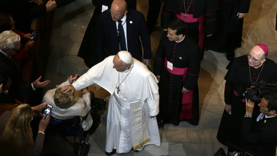 Pope Francis touches a woman in a wheelchair after he addressed a gathering in Saint Martin's Chapel at St. Charles Borromeo Seminary, on Sunday. (Mel Evans/AP)