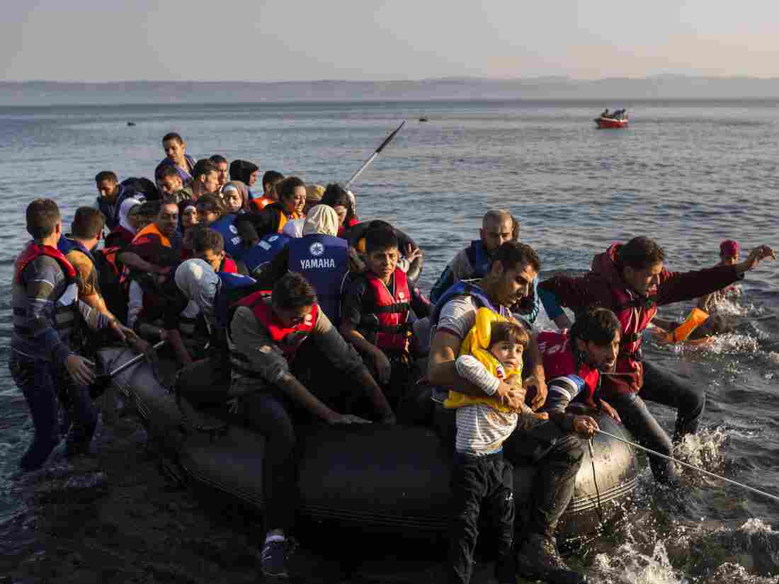 Migrants from Syria and Afghanistan arrive on an overcrowded dinghy from the Turkish coasts to the Greek island of Lesbos, Monday, July 27, 2015.
